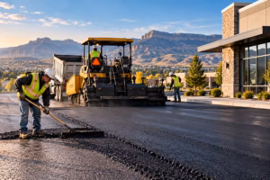 Commercial asphalt paving crew laying fresh pavement with heavy equipment at a Billings, Montana site.